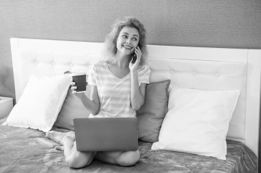 Kadın serbest çalışanın telefonda konuşmasına sevindim. Serbest çalışan kadın telefonda konuşuyor. Dizüstü bilgisayarı ve kahvesi olan serbest çalışan bir kadın telefon görüşmesi yapıyor..