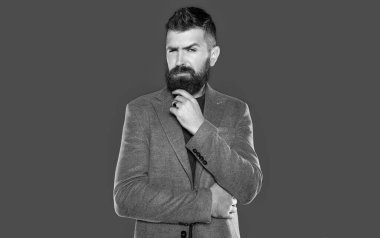Sakallı düşünceli adam gri arka planda rahat giyinir..