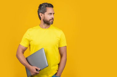 Adam blogcu sarıda izole edildi, boşluğu kopyala. Arka planda bir blog yazarı. Stüdyoda blog yazarı. Dizüstü bilgisayarı olan bir adam blogcusunun fotoğrafı.