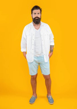 Arka planda şık bir beyaz adam. Beyaz adamın yaz modası giymiş şık bir fotoğrafı. Sarıda izole edilmiş modaya uygun beyaz adam. Stüdyoda şık beyaz adam.