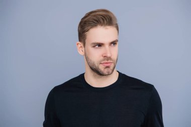 Kendine güvenen adam portresi. Erkeklerin cilt bakımı. Erkek derisi. Adamın şık bir saç kesimi var. Moda saç stili olan bir adam. Sıradan erkek tarzı. Kafkasyalı genç adam gri yolda izole edilmiş..