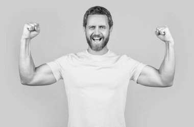 Stüdyoda tişört giydiğine sevindim. Mutlu adamın tişört giydiği fotoğraf. Mutlu adam sarı tişört giyer. Mutlu adam arka planda t-shirt giyiyor..