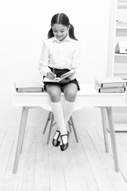 Not defterine not alan neşeli liseli kız. Liseli kızların not aldığı bir fotoğraf. Genç kız sınıfta not alıyor. Genç kız masaya not bırakıyor..