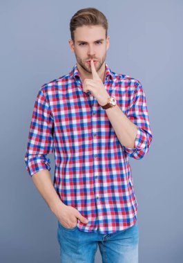 Adam sessiz sedasız sır saklıyor. Normal erkek stili. Erkeklerin güzellik anlayışı. Kafkasyalı milenyum adamı. Kareli tişörtlü adamın gri üzerinde gizli bir bölmesi var. Saç stili olan yakışıklı bir genç. Sessiz ol..