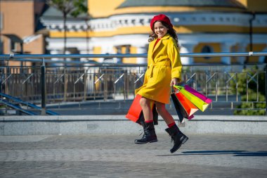 Sonbahar şehrinde gezen kız. En iyi satış teklifi. Sonbaharda alışveriş yapan genç bir moda kızı. Sonbahar alışverişi. Genç kız sonbahar kıyafetiyle alışverişe gider. Alışveriş ve indirim. Boşluğu kopyala.