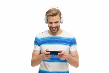 Beyazlar içinde izole edilmiş oyun için akıllı telefon kullanan bir adam. Akıllı telefondan oyun oyna. Oyun yaşam tarzı. Müzik ve oyun. Kulaklıklı erkek oyuncu akıllı telefon uygulaması ile çevrimiçi video oyunu oynuyor.