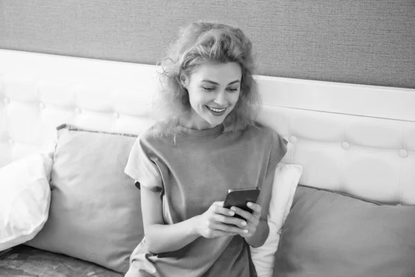 cheerful girl relax at home and messaging on phone. girl messaging on phone on the bed. phone messaging of girl.