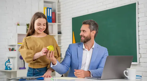 smiling teen child with man teacher in classroom. education.