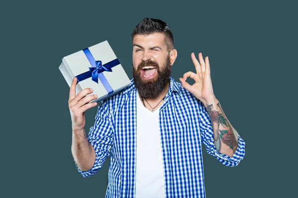 mature bearded man with present box on grey background. ok.