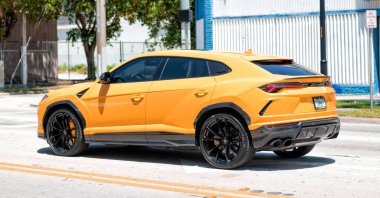 Miami Beach, Florida USA - April 15, 2021: 2019 Yellow Giallo Auge Lamborghini Urus, back corner view.