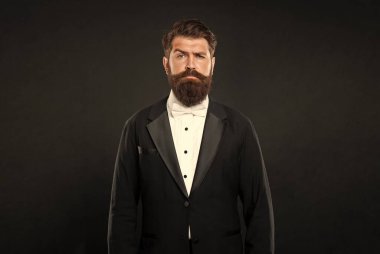 Smokin papyonlu ciddi bir adam. Siyah arka planda resmi giyinen bir adam. erkek resmi moda.