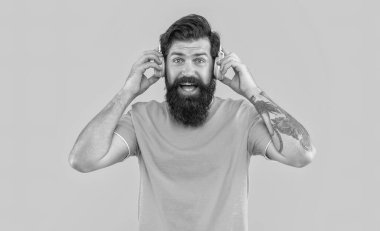 Müzik dinliyordum. Şaşırmış adamın modern aleti. Sarıda izole edilmiş kulaklıkla müzik dinleyen havalı adam. Havalı kulaklıklı adam müzik dinliyor. Kulaklıklı havalı adamın stüdyo fotoğrafı..