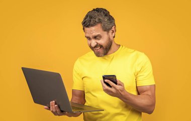 Hüsrana uğramış bir adamın stüdyosu var. Erkek asistanın fotoğrafı laptoptan aranmış. Asistan sarı hattan izole edilmiş. Adam asistanının arka planda çağrısı var.