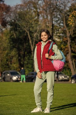 Açık havada liseli bir genç kız. Okullu genç kız dışarıda. Sırt çantalı liseli kız. Okullu genç kızın parkta fotoğrafı..