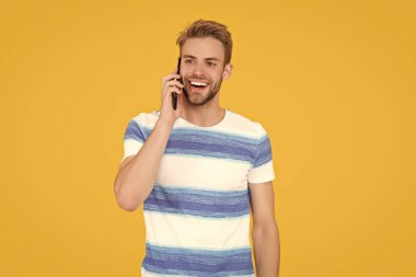 Mutlu adam telefonda sarıda izole bir şekilde konuşuyor. Adam stüdyoda telefonla görüşüyor. Adam ailesi ve arkadaşlarıyla konuşmak için telefonunu kullanıyor. Telefonlu bir adam konuşuyor..