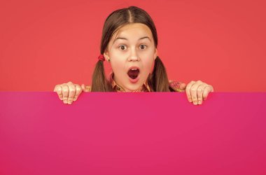 Reklam için fotokopi alanı olan boş pembe kağıdın arkasında hayrete düşmüş bir çocuk..