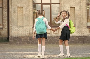 Okul çantalı iki liseli kız dışarıda beraber yürüyor. Okula geri dön..