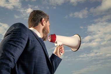 İş adamı arka planda hoparlörle yüksek sesle bağırıyor.