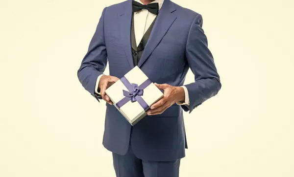mature man in suit with birthday present isolated on white.