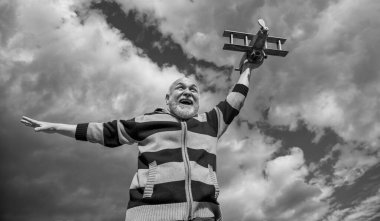 Gökyüzü geçmişindeki kıdemli boz adam. Emeklilikteki son sınıf. Dışarıda oyuncak uçağı olan yaşlı emekli bir adam..