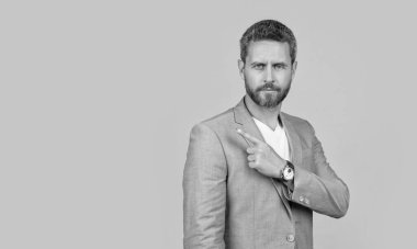 Resmi ceketli, işaret parmağı takan bir adam. Sarı arka planda yalıtılmış beyaz ceketli bir adam. Stüdyodaki adam. Takım elbiseli yakışıklı bir adamın fotoğrafı..