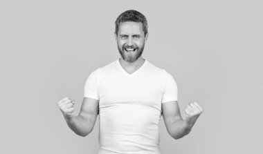 Sarı arka planda izole edilmiş günlük gömlekli neşeli sakallı adam. Stüdyoda sıradan bir adam. Beyaz gömlek giyen beyaz bir adamın fotoğrafı. Sıradan giyinen bir adam..