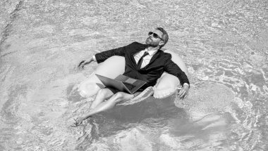 Adam tüccar işi ve ringde yüzme havuzunda rahatlamak. Adam tüccar işi ve dizüstü bilgisayarla rahatla. İnsan ticaretinin fotoğrafı ve havuzda rahatlamak. Adam tüccar işi ve rahatlama.