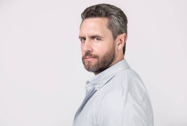 Gri arka planda sakallı ve fotokopi alanı olan olgun bir adamın yüzü. Stüdyoda sakallı, olgun bir adam. Sakallı, olgun bir adamın fotoğrafı. Kirli sakallı, normal gömlekli olgun bir adam..