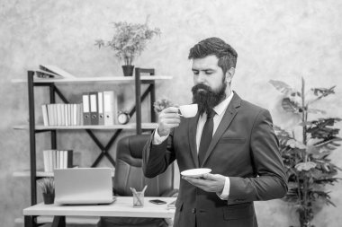 mature entrepreneur in jacket enjoying coffee break at office, guy.