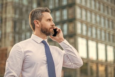 Patron akıllı telefon konuşması yapıyor. Patronun akıllı telefon konuşması. Akıllı telefonlu patron konuşuyor. Akıllı telefonlu patronun iş görüşmesi..