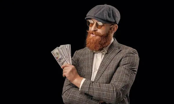 photo of cheerful rich retro man with money wear peaked cap. rich retro man with money isolated on black. rich retro man with money in studio. rich retro man with money on background.