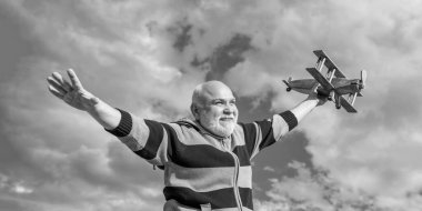 happy retirement. cheerful granddad with toy. retired old man outdoor. senior man at retirement on sky background.