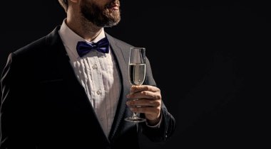 Smokinci stüdyoda fotokopi odasıyla tezahürat yapıyor. Smokinli adam şampanyayla tezahürat yapıyor. Amigo smokinli adamın fotoğrafı. Smokinli adam, siyah arka planda tek başına tezahürat yapıyor..