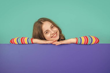 Boş mavi kağıdın arkasında reklam için fotokopi alanı olan mutlu çocuk.