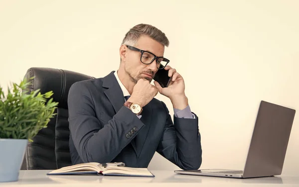 busy office worker in eyewear talking on phone with computer.