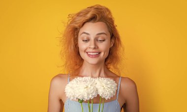 Arka planda kadınlar günü çiçekleri olan hayret verici bir kadın. Kadınlar Günü 'nde kasımpatı çiçeği olan bir kadının fotoğrafı. Kadınlar günü çiçekleri olan kadın sarıda izole edilmiş. Stüdyoda elinde kadın çiçekleri olan bir kadın..