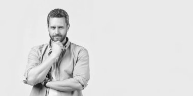 Gri arka planda sakallı, karizmatik stil sahibi bir adam. Stüdyoda sakallı, olgun, şık bir adam. Sakallı, olgun bir adamın fotoğrafı. Kirli sakallı, şık, olgun bir adam. Günlük gömlek giyiyor..