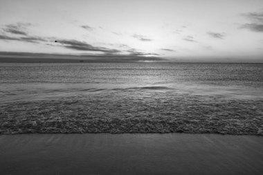 Deniz suyuyla yaz kumsalında güzel bir alacakaranlık.