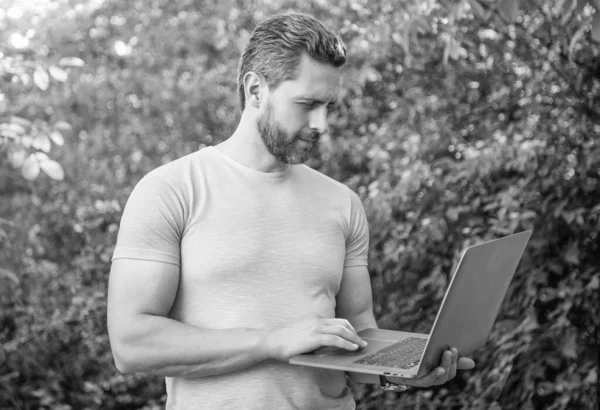 image of freelancer man freelancing online with laptop outdoor.