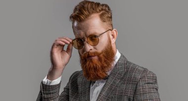 Resmi takım elbiseli sakallı beyefendinin zarafeti. Resmi kıyafet. Formalite icabı smokinli adam gride tek başına. Formalite içinde smokin giyen kızıl saçlı adam. Erkekler şık erkek kıyafetleri giyer..