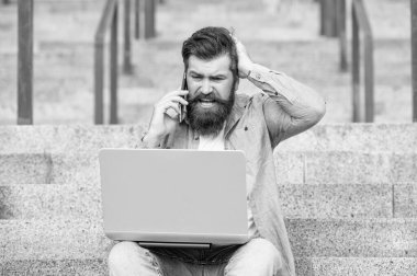 Şok olmuş bir adamın merdivenlerde çevrimiçi video bağlantısı var. Adamın bilgisayarında çevrimiçi video bağlantısı var. Adamın dışarıda online video iletişimi var. Adamın dışarıda internet bağlantısı var..