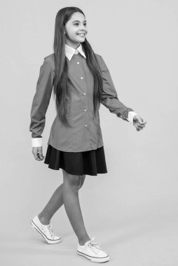 Genç kız sarı yolda tek başına yürüyor. Stüdyodaki genç kız. Arkaplanda genç bir kız var. Üniformalı bir genç kızın fotoğrafı..