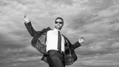 Takım elbiseli neşeli iş adamının fotoğrafı. Gökyüzü geçmişinde takım elbiseli bir iş adamı. Takım elbiseli iş adamı. Takım elbiseli iş adamı.