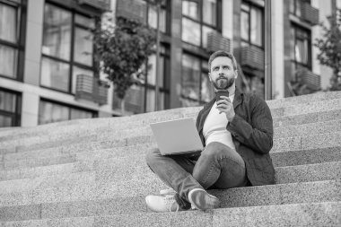 Bilgisayarlı serbest çalışan bir adamın resmi. Dışarıda dizüstü bilgisayarı olan serbest çalışan bir adam. Sokaktaki serbest çalışan adam. Dışarıda polisle serbest çalışan bir adam..