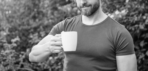 cropped photo of man with coffee. man with coffee. man with coffee in hat. man with coffee outdoor.