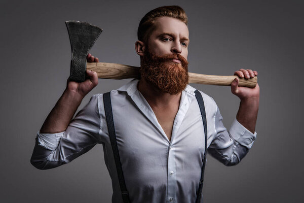 Masculinity of bearded man with axe isolated on grey. Caucasian brutal man with beard and moustache. Masculine energy. Retro style. Handsome and charismatic. Masculine man. Creative hairstyling.
