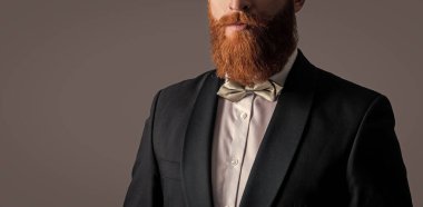 Uzun sakallı berber mahsulü manzarası. Sakallı ve bıyıklı, tıraşsız bir yüz. Papyon stüdyosunda sakallı ve bıyıklı İrlandalı erkek. Gri, kopyalama alanında izole edilmiş..