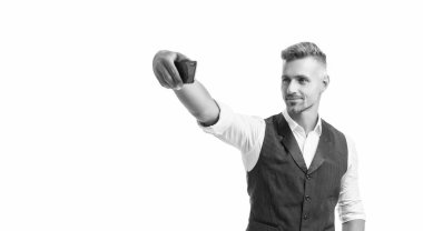 Takım elbiseli mutlu profesyonel adam, beyazda izole edilmiş akıllı telefonuyla selfie çekiyor..