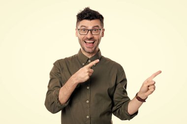 Kafkasyalı yönetmen stüdyoyu işaret etti. Yönetmen beyaz arkaplandan izole edilmiş. Gözlüklü yönetmen. Yetişkin yönetmen tişört giyiyor.