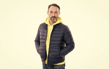 Beyaz adam stüdyoda kalın bir ceket giyer. Olgun bir adam için sonbahar ceketi. Olgun bir adamın kalın ceketi. Ceketli olgun bir adam beyaz arka planda izole edilmiş..